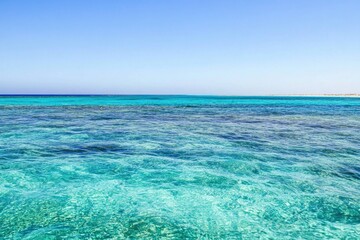 Obraz premium A calm sea and distant coastline from the perspective of a boat