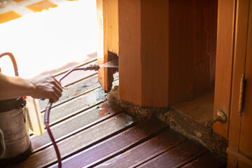 young man chooses to use termite control chemicals that are not toxic to humans mixed with water in...