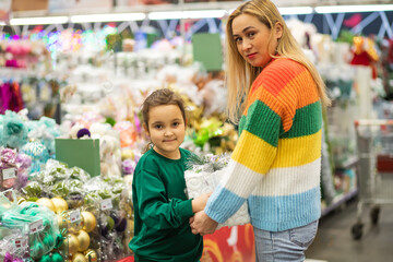 Family mom and daughter shopping Christmas presents and decoration in shopping mall