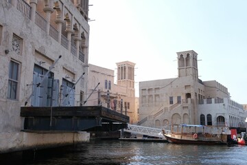 Naklejka premium Beautiful view of historical and traditional buildings of Arab culture in Bur Dubai district from Dubai Abra while crossing in boat.