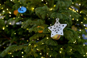 Colorfull Christmas decorations with star, lights in a spruce trees.
