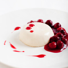 Panna cotta dessert with cherry berry on a plate. Traditional Italian dessert. White background....