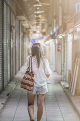 female tourist is happily traveling in Thailand and it is country where you can walk around safely. Behind Asian female tourist is walking according her planned program in Thailand because it is safe.