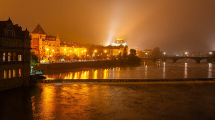 Fototapeta premium Panoramic view of the city of Prague at night in a magical foggy atmosphere, Czech Republic.