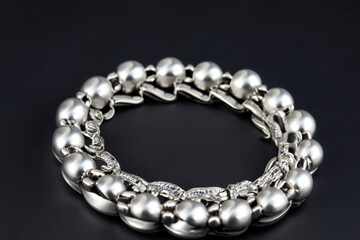 Obraz premium Black bracelet with a white background. Silver bracelet black background decoration gray lies. A black and gray bracelet lying on a black background. A silver bracelet with diamonds on it lifestyle.