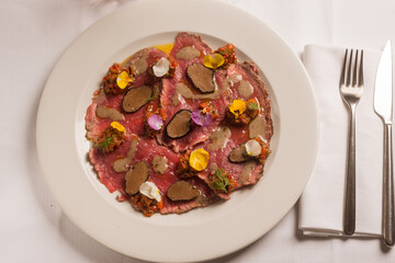 meat carpaccio with sliced truffle and flowers