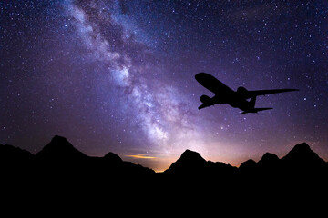 Milky Way and silhouette of a airplane. Landscape with passenger airplane is flying in the starry...