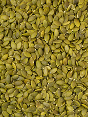 Photograph of a pile or stack of hulled pumpkin seeds without shell isolated on white background