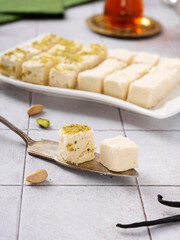 Turkish vatka - tender pashmak halva on a plate, in the form of square cubes, with a cup of Turkish tea.