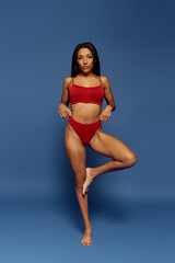 Fototapeta premium A confident young African American woman models stylish underwear in a studio setting.