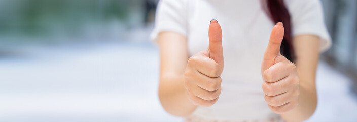 The girl held her thumb up with her hands, a positive sign