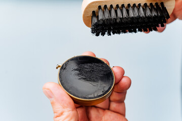 A focused individual holds a paintbrush in one hand and a colorful object in the other, eager to...