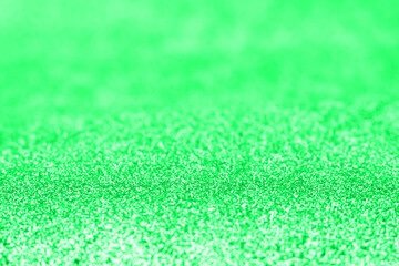 Fototapeta premium Abstract green glitter blurred holiday texture.