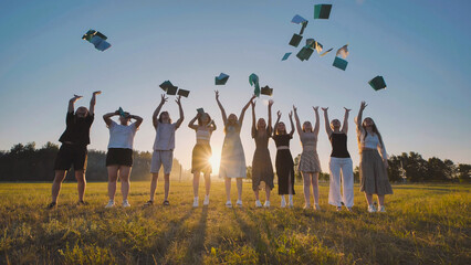 Young graduates tossing their books in the air, celebrating the completion of their studies at...