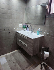 Newly installed small modern bathroom  multi-tone gray tiling. bathroom in gray tones
