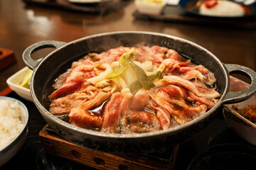 Close up of beef or pork nabe, Nabemono or sukiyaki, or Wagyu beef in a cast iron pan. Japanese tradition food, hot pot lunch or dinner, Japanese restaurant. delicious and yummy Japan food.