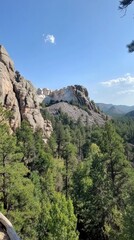 Fototapeta premium Explore the stunning landscape surrounding Mount Rushmore with its towering granite sculptures and lush greenery under a clear blue sky
