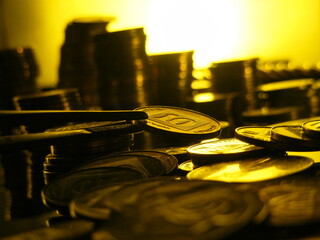 
Israeli coin 10 agorot with reflections from the sun. 
Close-up of an Israeli coin against the background of other coins.