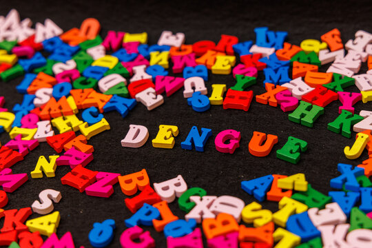 Colorful Wooden Letters Spelling "DENGUE" on a Black Background for a Striking Visual Presentation