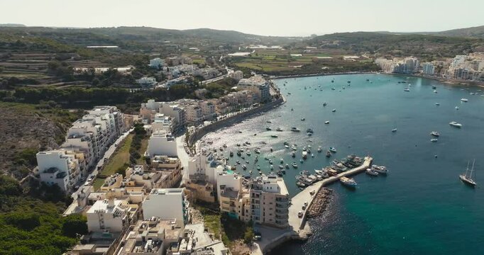 Aerial view of the marina in Bugibba, Malta. Tourist landscape boats yachts moored on the embankment in the Mediterranean Sea. High quality 4k footage