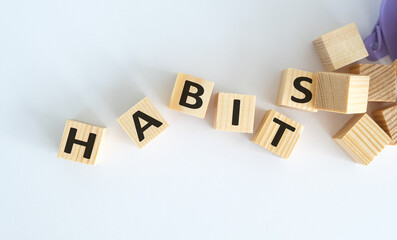 Habits - text on wooden cubes on white background.