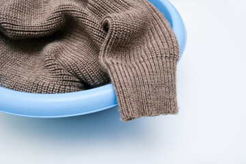 Hand washing of delicate woolen knitted clothes, sweaters concept, care of bright color clothes