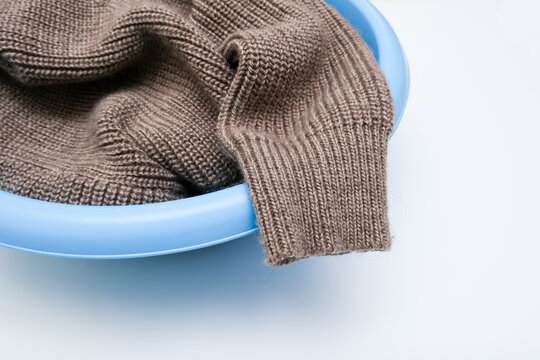 Hand washing of delicate woolen knitted clothes, sweaters concept, care of bright color clothes