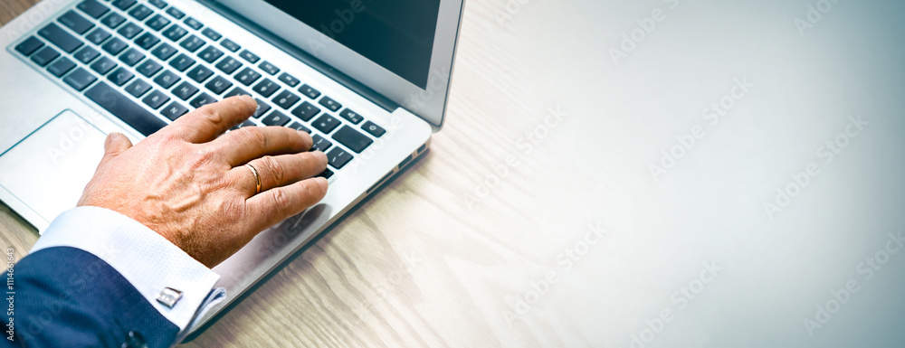 Poster banner with mature man working on laptop. forefinger at keyboard closeup. male entering information.