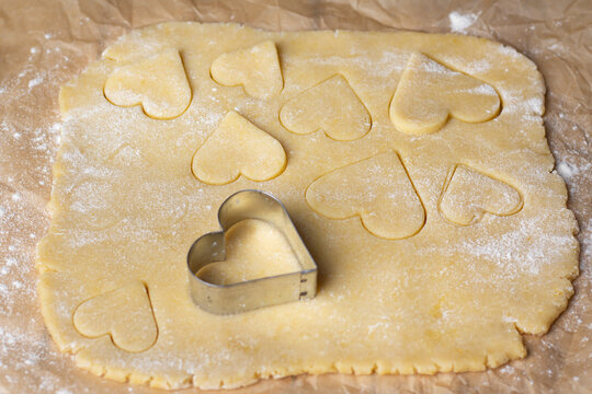 Heart-shaped cookie dough prepared on a floured surface for baking - Powered by Adobe