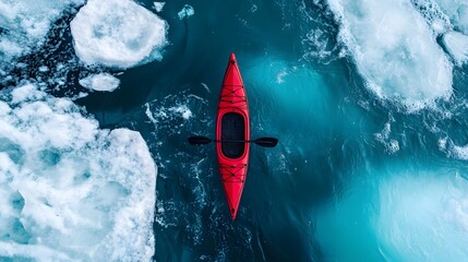 Exploring icy waters in a vibrant red kayak amidst floating icebergs