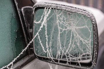 frosted car wing mirror with iced cobwebs
