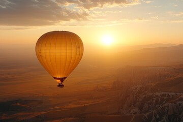 Obraz premium A solitary hot air balloon glides peacefully above the striking landscapes of Cappadocia, kissed gently by the sunrise, radiating freedom and serenity.