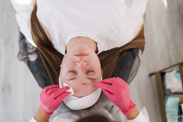 Top view of skincare professional performs a deep pore cleansing treatment, using a gentle tool to...