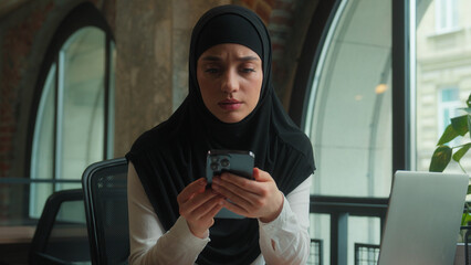 Muslim islamic hijab business woman businesswoman office worker working laptop receive sms mobile...