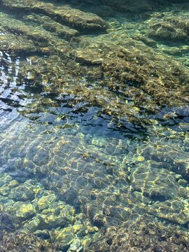 The sea water is clear and clean with a rocky bottom.