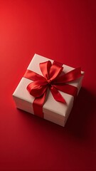 Obraz premium beautifully wrapped gift box adorned with a red ribbon on a rich red background, symbolizing celebration and festive cheer, vertical orientation.