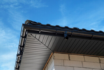 Roof corner with modern guttering and clear blue sky during the afternoon