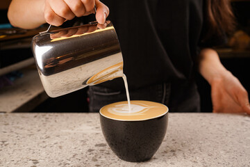 Close-up of the process of brewing cappuccino coffee with thick milk foam from the cappuccinatore.