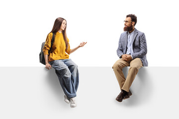 Naklejka premium Female teenager sitting on a panel and talking to a bearded man