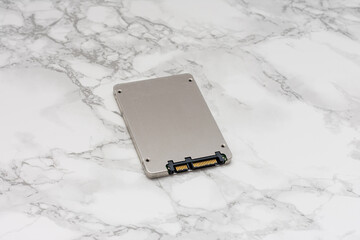 Silver computer hard drive sits on a marble countertop