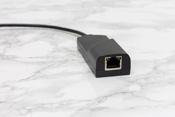 Black External Network Adapter with RJ45 Port on a White Surface