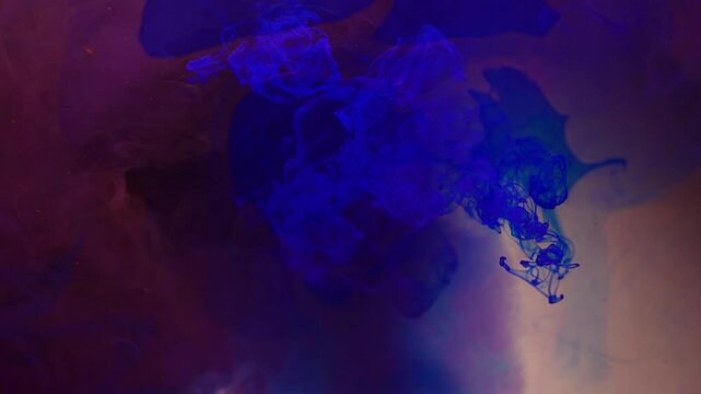 Abstract background. Blue ink disintegrates in water creating a hypnotizing image.