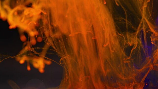 Abstract background.Orange ink disintegrates under the influence of water.