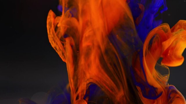 Abstract background.Blue ink combines with orange ink while dynamically mixing.