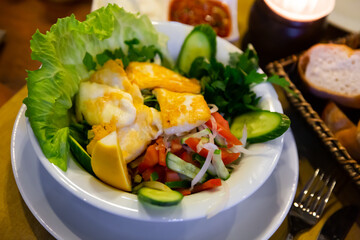 Delicious fried halloumi cheese served with salad of vegetables and greens and lemon. Traditional Turkish cuisine