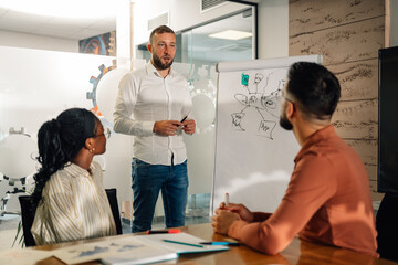 Manager explaining business strategy to colleagues in meeting room