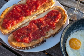 Traditional andalusian breakfast on roof patio with bread toasts, fresh ground tomatoes sauce and olive oil, Sevilla, Andalusia, Spain.