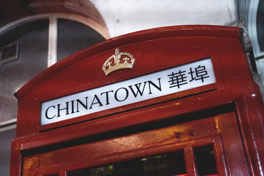 Historic red telephone booth with Chinatown sign and crown emblem