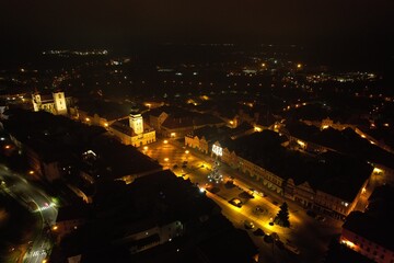 Fototapeta premium Aerial night panorama of Zatec old town center during Christmas time, illuminated with festive lights and decorations, capturing the magic of this historic Czech town.