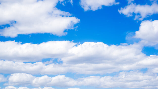 Background or backdrop of beautiful white clouds over blue sky. Lines or cloud condensation across the sky. Sky art lines occur when aircraft exhaust condenses, clouds freeze. Ideal for designers